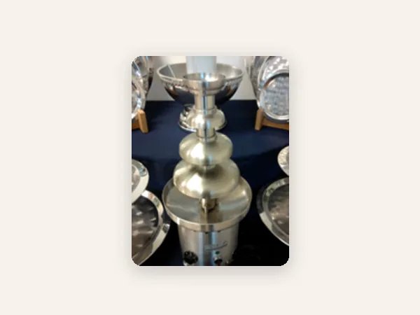 Stainless steel tiered chocolate fountain on a display table