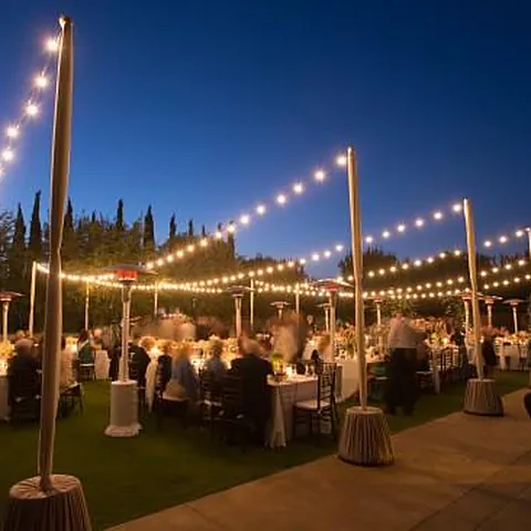 Outdoor dinner under string lights at dusk