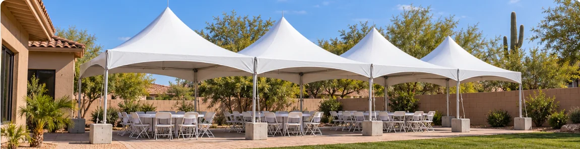 Four white 20 by 20 High Peak tents with tables and white folding chairs in an Arizona backyard