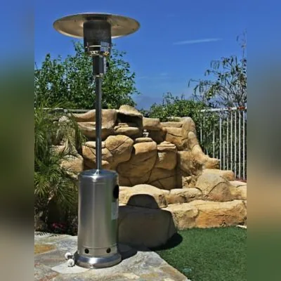 Tall stainless propane patio heater on a backyard patio